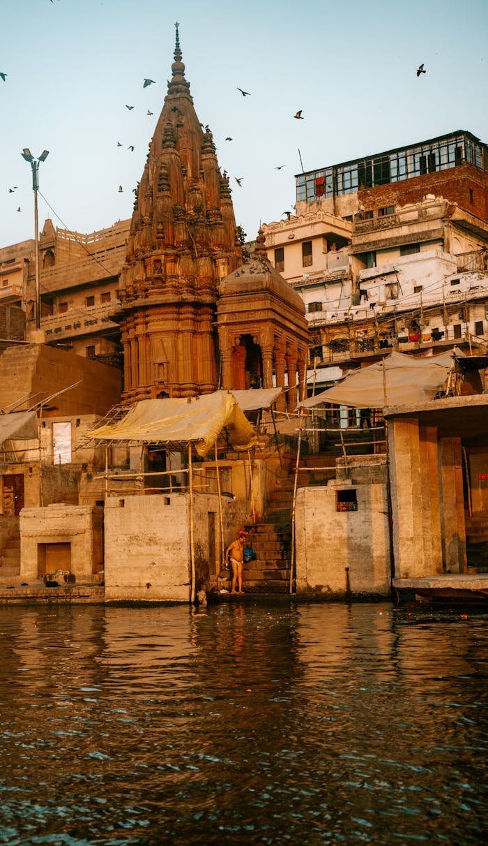 Beautiful Varanasi temple by the Ganges River at sunrise showcasing rich cultural and architectural heritage.