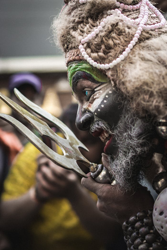 Captivating portrait of a traditional performer during a Hindu ritual in Varanasi, India.