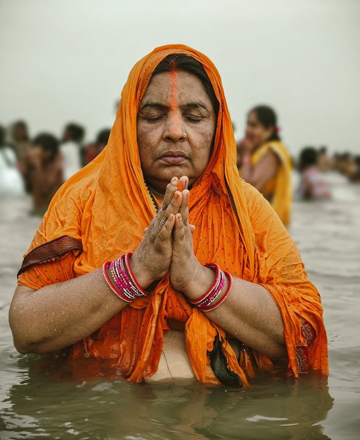 Indian woman performing Chhath Puja in Ganga River, symbolizing devotion and tradition in Patna, India.