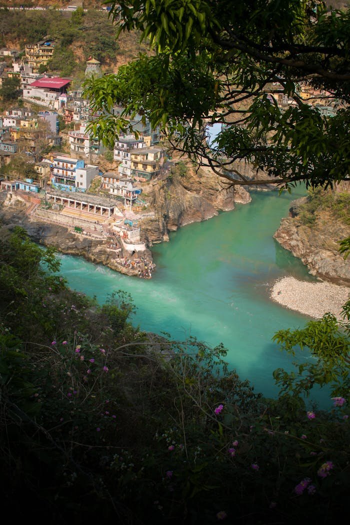 A breathtaking view overlooking the vibrant river bend at Karnaprayag, India, nestled among lush greenery.