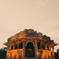 Capture of the Sun Temple in Modhera, Gujarat, showcasing ancient Indian architecture against the warm hues of sunset.